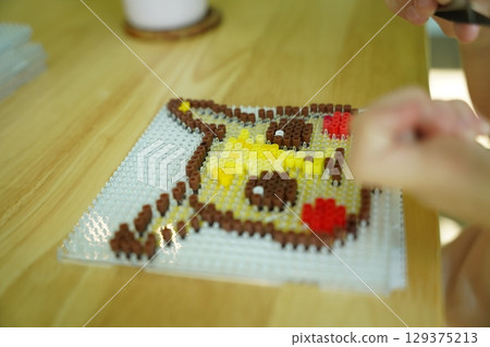 Teacher in workshop teched two girls how to assemble a thermo mosaic Teacher in workshop teched two girls how to assemble a thermo mosaic 129375213