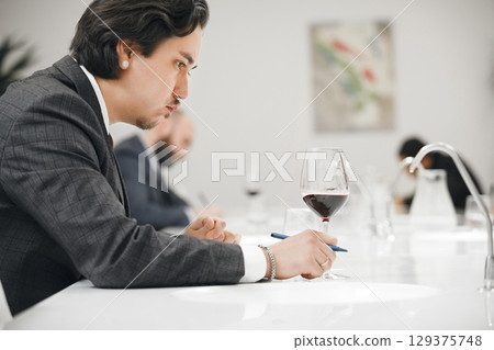 Professional Sommelier Assessing Wine Quality by Means Smell, Taste and it Color. Professional Sommelier Assessing Wine Quality by Means Smell, Taste and it Color. 129375748