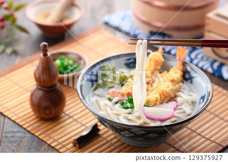熱氣騰騰的新鮮天婦羅烏龍麵,配上紫蘇葉、炸蝦、星形胡蘿蔔和蔥花。溫暖的日式冬季午餐。 熱氣騰騰的新鮮天婦羅烏龍麵,配上紫蘇葉、炸蝦、星形胡蘿蔔和蔥花。溫暖的日式冬季午餐。 129375927