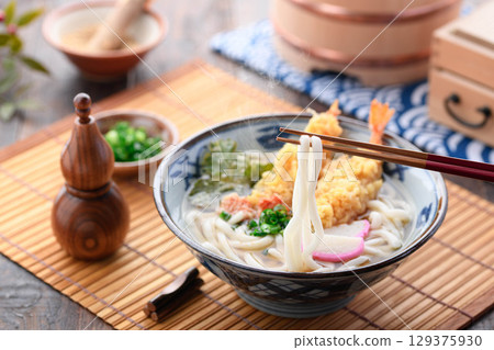 Steaming freshly made tempura udon noodles with shiso leaves and shrimp tempura, star-shaped carrots, and green onions. A warming Japanese winter lunch. Steaming freshly made tempura udon noodles with shiso leaves and shrimp tempura, star-shaped carrots, and green onions. A warming Japanese winter lunch. 129375930