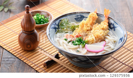 Steaming freshly made tempura udon noodles with shiso leaves and shrimp tempura, star-shaped carrots, and green onions. A warming Japanese winter lunch. 129375936