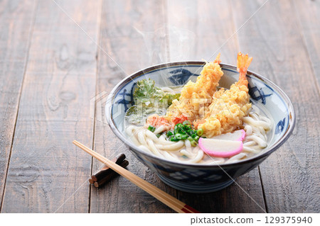 Steaming freshly made tempura udon noodles with shiso leaves and shrimp tempura, star-shaped carrots, and green onions. A warming Japanese winter lunch. Steaming freshly made tempura udon noodles with shiso leaves and shrimp tempura, star-shaped carrots, and green onions. A warming Japanese winter lunch. 129375940