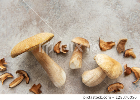 Fresh penny bun mushrooms and dried slices on table 129376056