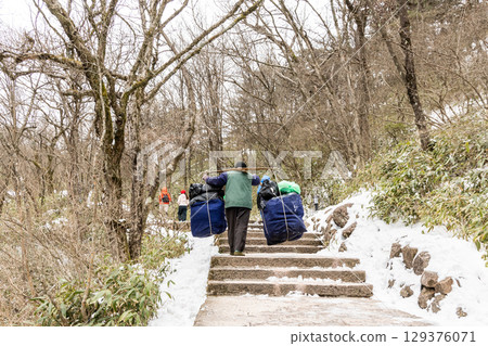 Porter workers carrying construction materials along steep steps at Huangshan or Yellow Mountain. Porter workers carrying construction materials along steep steps at Huangshan or Yellow Mountain. 129376071