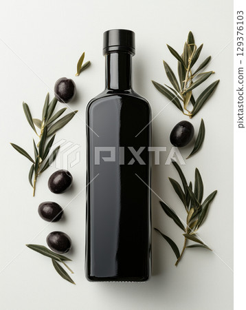 sleek black olive oil bottle surrounded by fresh olives and olive branches 129376103