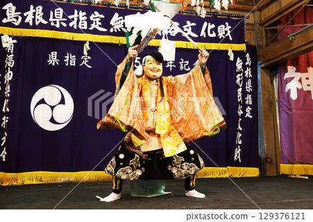 Iwami Kagura (Night Kagura) Performers dancing on the shrine's worship hall stage 129376121