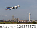 A plane taking off with the control tower in the background 129376573