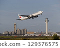 A plane taking off with the control tower in the background 129376575