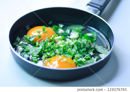 fried egg or sunny side up egg with vegetable topping before fry fried egg or sunny side up egg with vegetable topping before fry 129376765