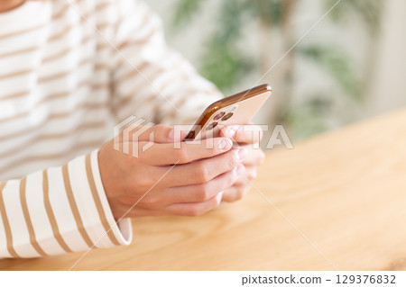 國中女生在家中操作智慧型手機 129376832