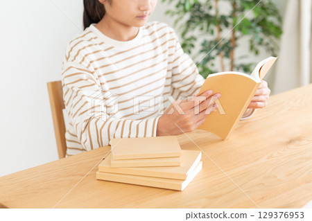 A middle school girl reading at home 129376953