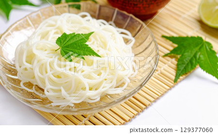 Chilled somen noodles served in a glass bowl with a green maple leaf design. Generative AI Chilled somen noodles served in a glass bowl with a green maple leaf design. Generative AI 129377060