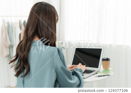 一位女士在家中使用電腦工作(完全遠端、遠距工作、遠距辦公) 一位女士在家中使用電腦工作(完全遠端、遠距工作、遠距辦公) 129377106
