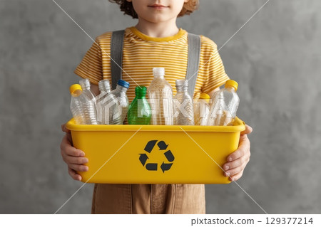 Child Holding Overflowing Recycling Bin with Plastic Bottles for Eco-Friendly Awareness Child Holding Overflowing Recycling Bin with Plastic Bottles for Eco-Friendly Awareness 129377214