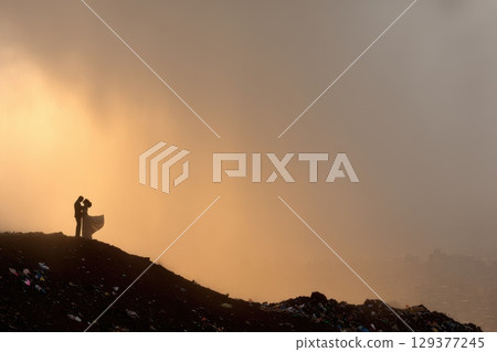 A man is standing on a hill looking at the city below A man is standing on a hill looking at the city below 129377245