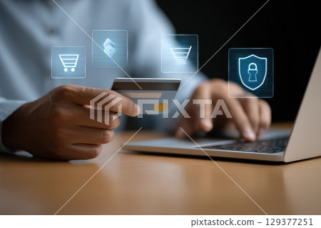 Person Holding Credit Card While Using Laptop for Online Shopping and Digital Transactions 129377251