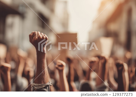 Group of People Participating in Climate Change Protest with Raised Fists and Signs 129377273