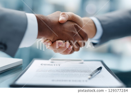 Business Partners Shaking Hands After Finalizing an Editorial Agreement in an Office Setting Business Partners Shaking Hands After Finalizing an Editorial Agreement in an Office Setting 129377284