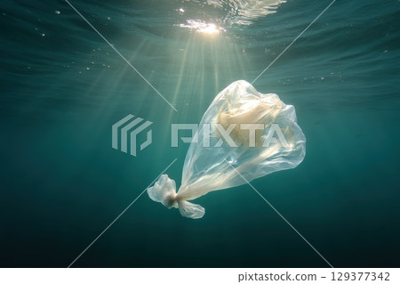 Dramatic Sunlight Filtering Through Ocean Surface Highlighting Floating Plastic Waste Underwater 129377342