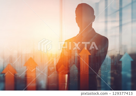 Man Silhouetted Against Abstract City Background with Graph-Style Arrows and Glass Wall 129377413