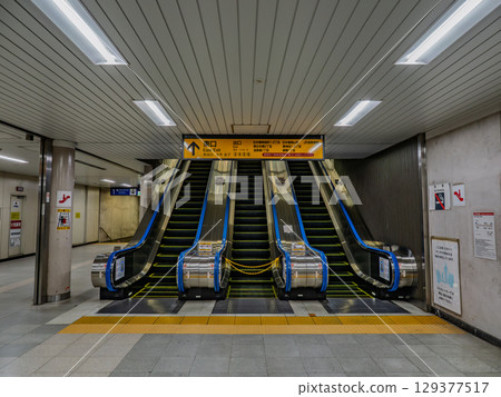 Three rows of escalators inside an underground train station (JR Bakurocho Station) Three rows of escalators inside an underground train station (JR Bakurocho Station) 129377517