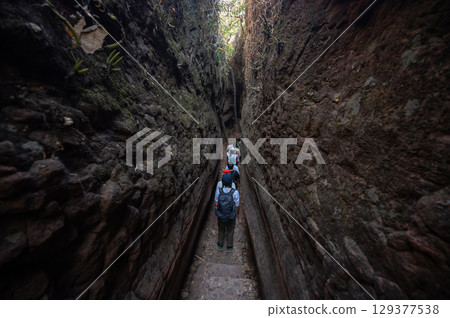 Tourist visiting the bizarre Naga Cave, located in the Bueng Kan province of Northeastern Thailand. This strange and amazing beauty of the large stone shaped like a giant snake. Tourist visiting the bizarre Naga Cave, located in the Bueng Kan province of Northeastern Thailand. This strange and amazing beauty of the large stone shaped like a giant snake. 129377538