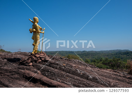The Buddhist monk statue situated on Phu Langka mountain in Bueng Kan province of Thailand. This site is a prime viewpoint to watch the sunrise and landscape as far as Laos. 129377593