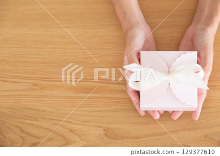 Hands of a middle school girl holding a present Hands of a middle school girl holding a present 129377610