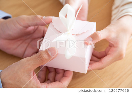 A middle school girl and her father holding a gift A middle school girl and her father holding a gift 129377636
