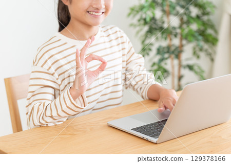 A middle school girl making a circle sign with her fingers in front of a computer A middle school girl making a circle sign with her fingers in front of a computer 129378166