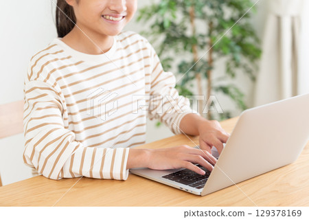 一名國中學生正在家中使用電腦 一名國中學生正在家中使用電腦 129378169