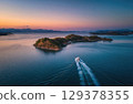A luxury yacht sailing between islands in the sea drone shot. 129378355