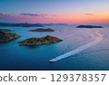 A luxury yacht sailing between islands in the sea drone shot. 129378357