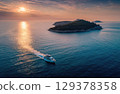 A luxury yacht sailing between islands in the sea drone shot. 129378358