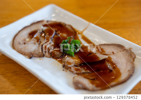 Chashu, a Japanese braised pork dish made with pork belly. It is a popular topping for ramen and other dishes. Chashu, a Japanese braised pork dish made with pork belly. It is a popular topping for ramen and other dishes. 129378452