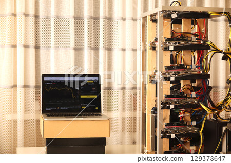 a homemade crypto mining rig, built from various computer components in a makeshift farm. The intricate construction is set against a simple background 129378647