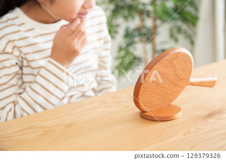 一名國中生用手鏡檢查自己的皮膚 129379326