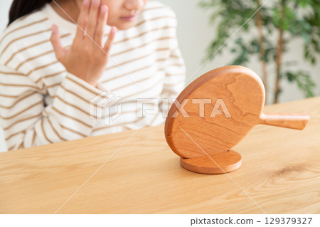 一名國中生用手鏡檢查自己的皮膚 129379327