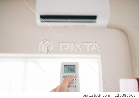 拿著冷氣遙控器的女人 拿著冷氣遙控器的女人 129380563