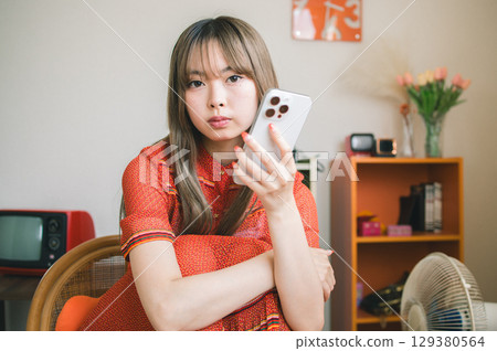 看智能手機的婦女在屋子裡 129380564