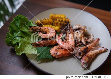 Grilled seafood platter Close-up meat platter with lemon wedges and dipping sauces. 129381012