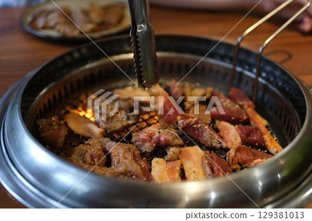 Grilled beef barbecue Cooked juicy steak meat beef brushed with rosemary on a flaming grill surrounded by other meat and sausages. slow motion Grilled beef barbecue Cooked juicy steak meat beef brushed with rosemary on a flaming grill surrounded by other meat and sausages. slow motion 129381013