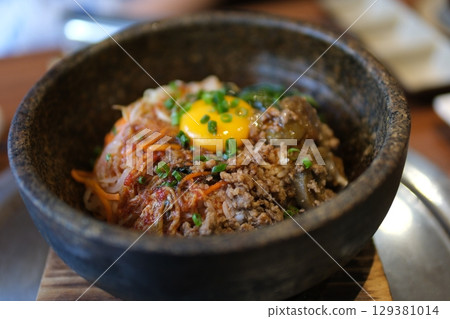 rice with raw egg Warm stone bowl with rice, seasoned vegetables, beef, and egg, mixed with spicy sauce. rice with raw egg Warm stone bowl with rice, seasoned vegetables, beef, and egg, mixed with spicy sauce. 129381014