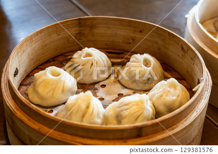 Shanghai popular xiaolongbao or little dragon dumpling steamed and served in bamboo basket. 129381576