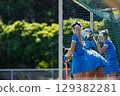 Field hockey players in blue uniforms focus on defending the goal 129382281