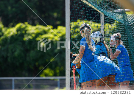 Field hockey players in blue uniforms focus on defending the goal Field hockey players in blue uniforms focus on defending the goal 129382281