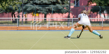 Female athlete passing the ball over the field. 129382282