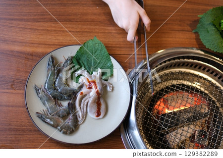 octopus squid cooking grill grills octopus seafood octopus mussels shrimp on hot bbq thai asian style, slow motion 129382289