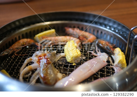 Grill BBQ octopus squid vegetables, corn, and bell peppers on the charcoal grill. 129382290