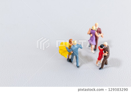 Miniature Couples Dancing on Light Background 129383290